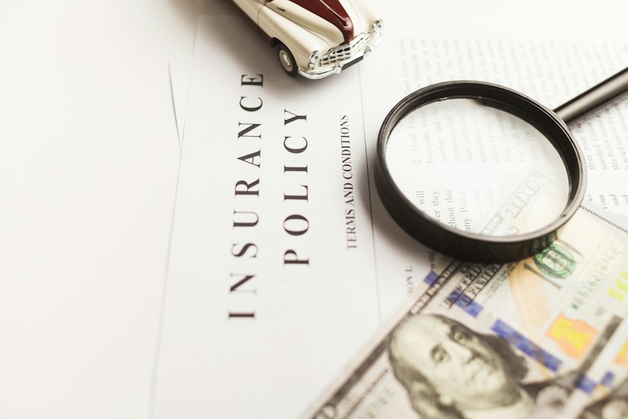 An insurance policy and claim paperwork under a magnifying glass