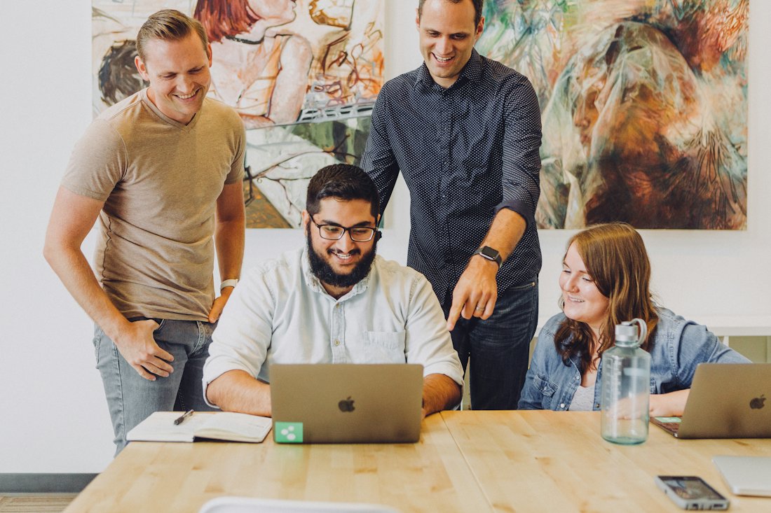 A team collaborating around a laptop in an office
