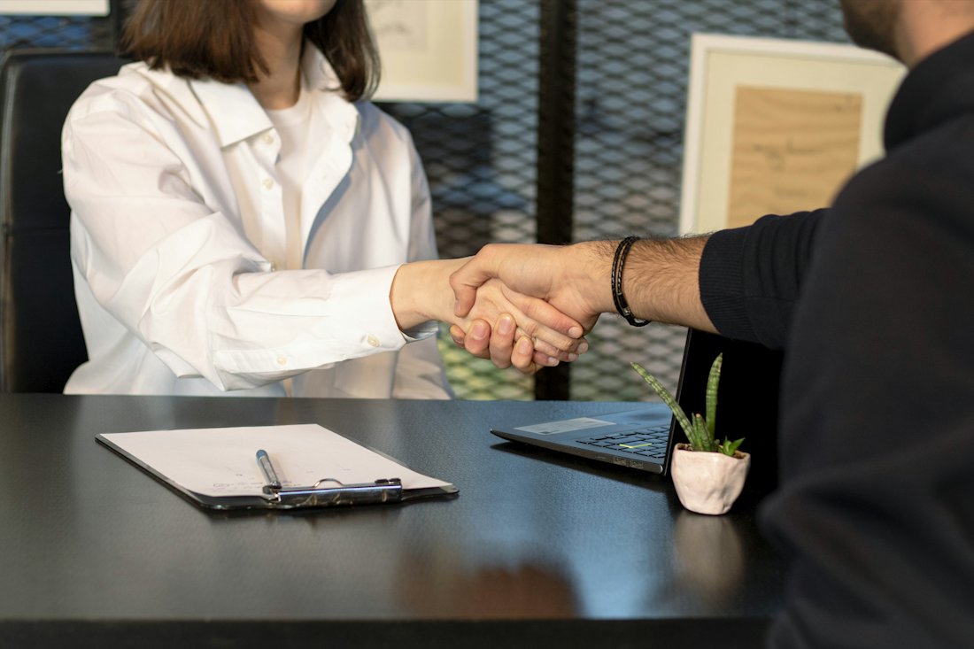 A client shaking hands with an attorney after agreeing to take the case