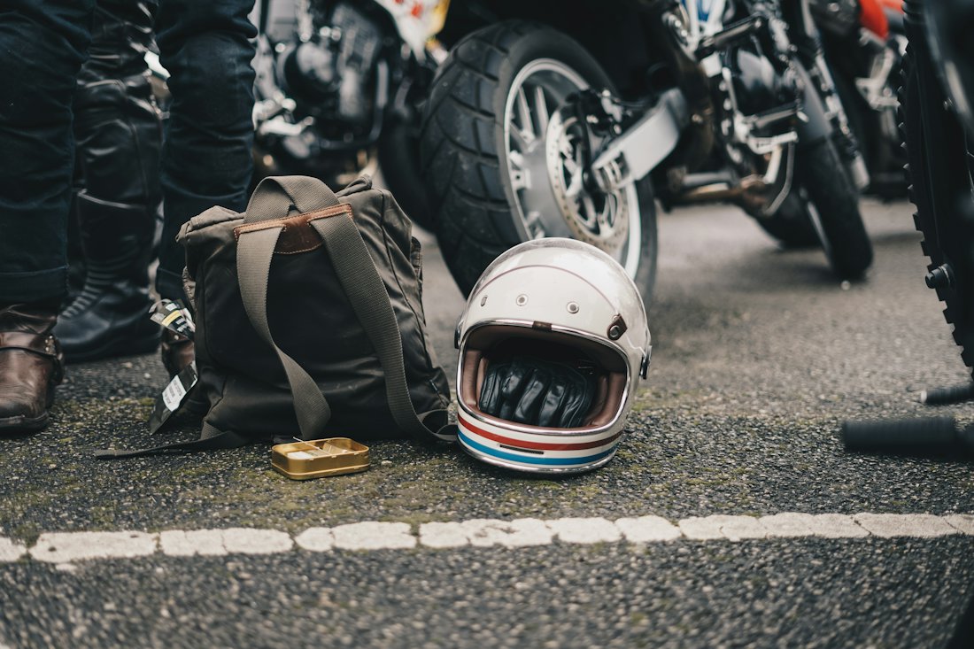 A rider's helmet on the road beside a fallen motorcycle