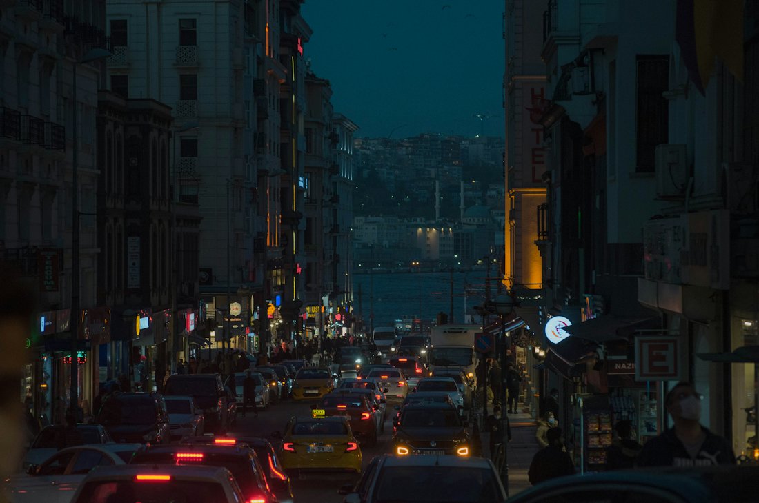 Evening traffic on a busy city street where rideshare cars pick up passengers